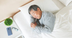 Senior man sleeping in bed peacefully at a Memory Care Community San Juan Capistrano