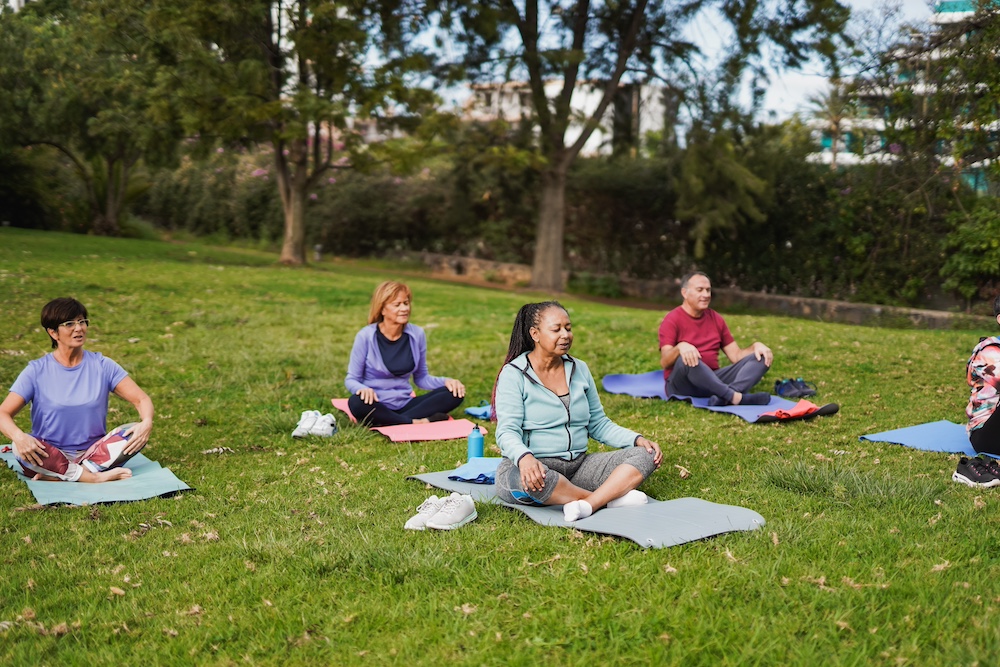 Seniors practicing meditation in garden